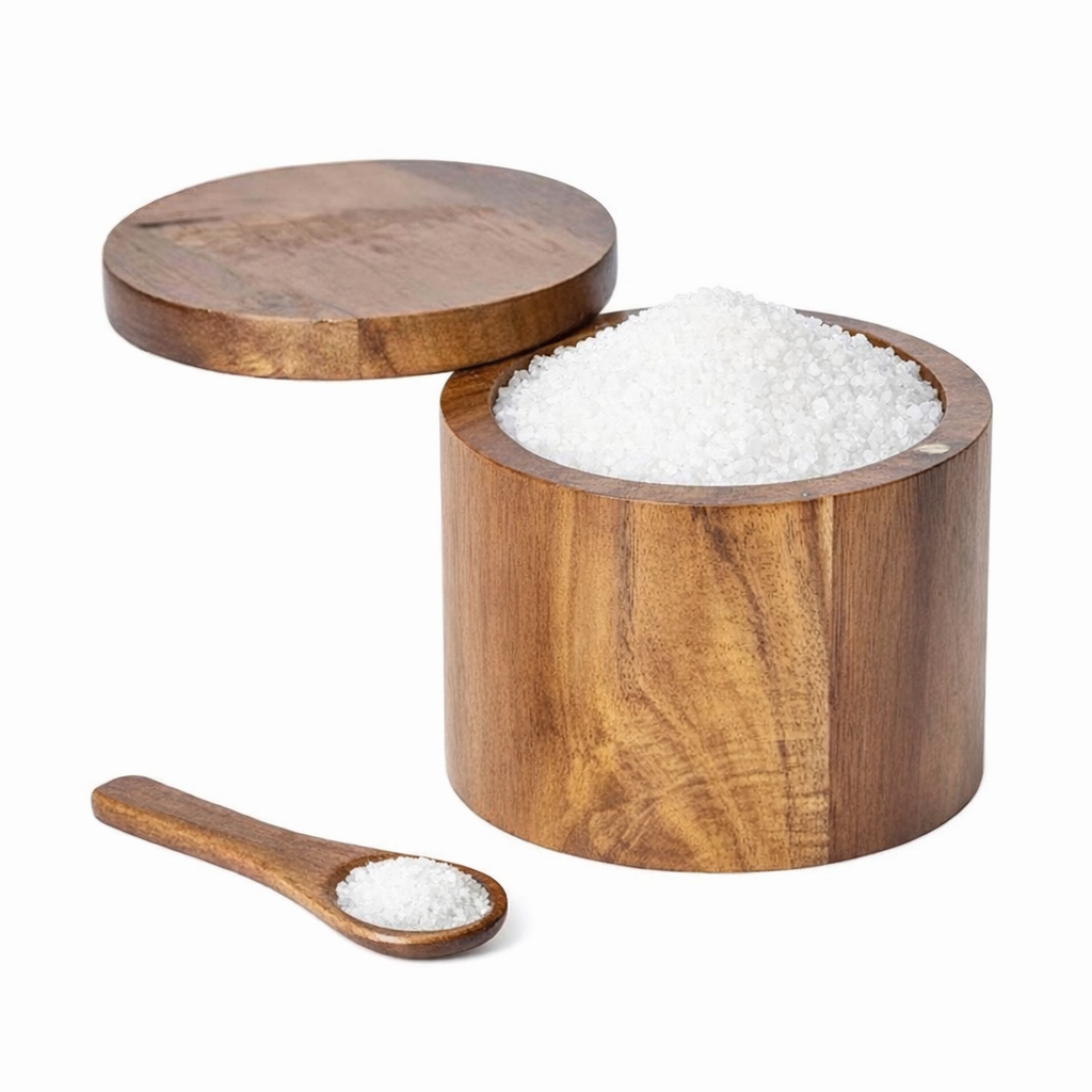 Acacia Wooden container with lid filled with salt, accompanied by a wooden spoon with salt on a white background.
