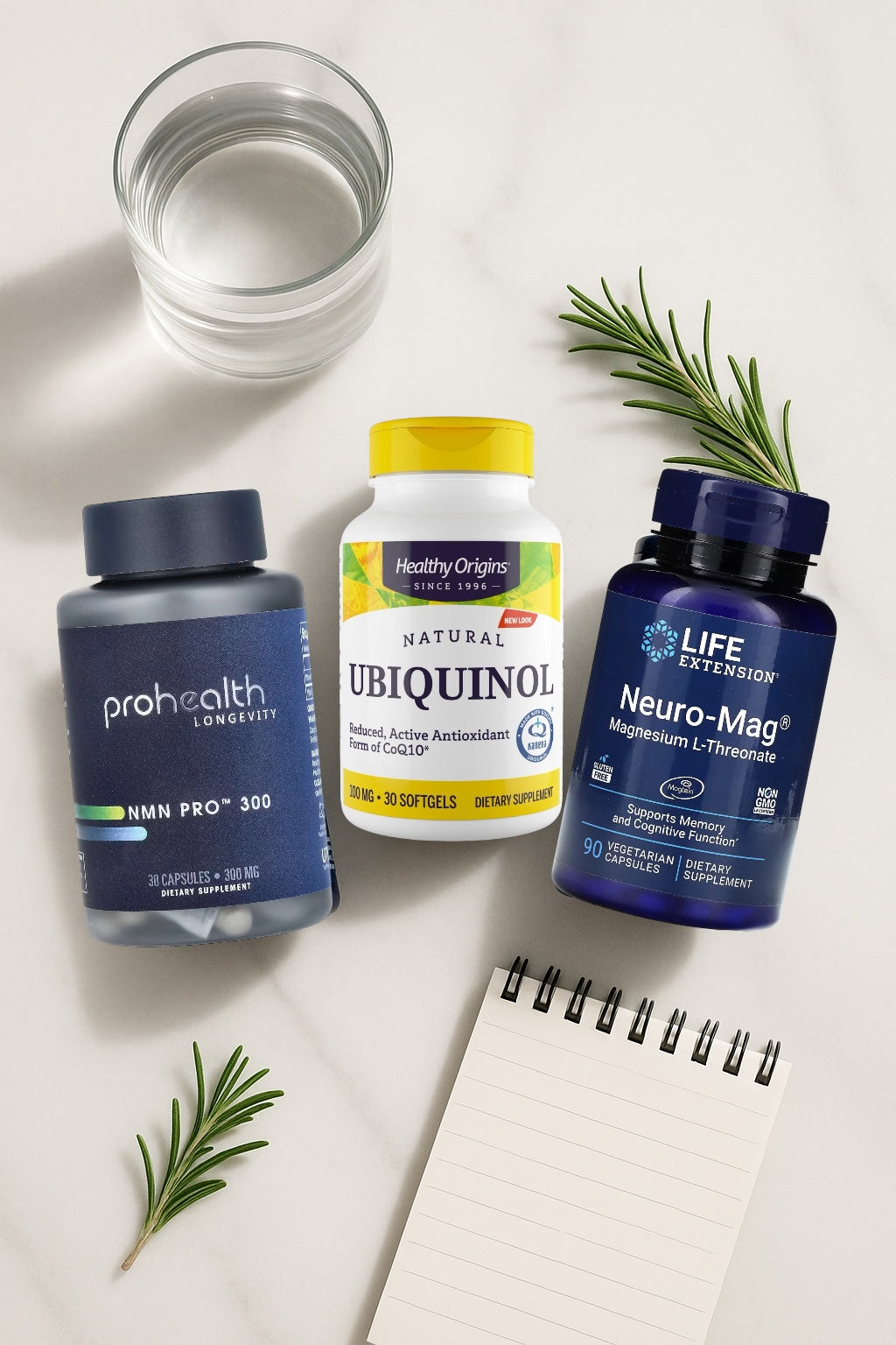 Three supplement bottles with a glass of water and a notepad on a light surface.