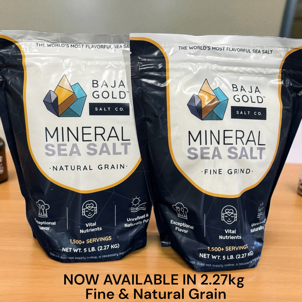 Two packages of Baja Gold Mineral Sea Salt on a wooden surface.